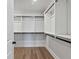 Bright walk-in closet features white shelving and black hardware for organizing clothes at 4024 Hosch Retreat Dr, Buford, GA 30519
