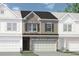 Charming townhome featuring a stone and siding exterior, two-car garage, and well-manicured landscaping at 16 Jacobs Farm Ln # 8, Lawrenceville, GA 30045