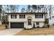 Charming two-story home with a well-manicured lawn, black garage door and shutters and arched front entry at 6660 Hidden Brook Trl, Atlanta, GA 30349