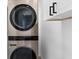 Modern laundry room showcasing stacked washer and dryer units near a door at 6660 Hidden Brook Trl, Atlanta, GA 30349