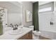 Bright bathroom with a shower, a toilet, a wooden vanity, a large mirror, and a white sink at 720 Shetland Trl, Cartersville, GA 30121