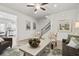 Bright living room with wood-look floors, neutral paint, ceiling fan, and stairs to the upper level at 720 Shetland Trl, Cartersville, GA 30121