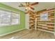 Unique bedroom featuring wood-look flooring, multiple windows and a rustic accent wall at 1408 Lake Paradise Rd, Villa Rica, GA 30180
