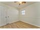 A well-lit bedroom featuring a ceiling fan, window with blinds, wood-look floors and closet at 1408 Lake Paradise Rd, Villa Rica, GA 30180