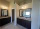 The bathroom features granite countertops, dual vanity sinks, dark cabinetry and large mirrors at 651 Deer Springs Way, Loganville, GA 30052