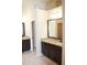 Bathroom with granite countertops, dark wood cabinets, and well-lit vanity mirrors at 651 Deer Springs Way, Loganville, GA 30052