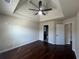 Bedroom featuring a tray ceiling, hardwood floors, ensuite bathroom, and natural light at 651 Deer Springs Way, Loganville, GA 30052