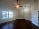 A bright bedroom featuring a ceiling fan, pendant lights, hardwood floors and a view to the exterior at 651 Deer Springs Way, Loganville, GA 30052