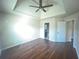 Bright bedroom with a tray ceiling, ceiling fan, and wood-look floors at 651 Deer Springs Way, Loganville, GA 30052