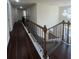 Hallway landing with iron railing, a dark wood floor, natural light, and chandelier at 651 Deer Springs Way, Loganville, GA 30052