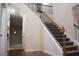 View of open staircase with carpeted steps and wrought iron spindles leading to the upper level at 651 Deer Springs Way, Loganville, GA 30052