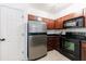 Compact kitchen equipped with stainless steel refrigerator and sleek black appliances, plus neutral tile flooring at 2700 Pine Tree Ne Rd # 4006, Atlanta, GA 30324