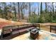 Outdoor patio featuring modern seating, a fire table, string lights, and a wooded backyard at 3457 Scenic Dr, East Point, GA 30344