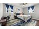 Bedroom with blue curtains, large windows, dark wood floors, and a workspace at 3457 Scenic Dr, East Point, GA 30344