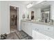 Bathroom featuring double vanities, granite countertops, and access to a walk-in closet at 744 Clark Lake Estates Dr, Grayson, GA 30017