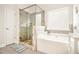 Modern bathroom featuring a glass shower, separate tub, and neutral tiling at 2031 Broadmoor Way, Fairburn, GA 30213