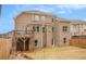 Brick home back exterior with wooden deck and patio overlooking the fenced lawn, combining charm and privacy at 2031 Broadmoor Way, Fairburn, GA 30213