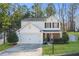 Charming two-story home featuring a white exterior, attached garage, manicured lawn, and mature trees at 455 Registry Blf, Stone Mountain, GA 30087
