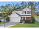 Charming two-story home featuring a white exterior, attached garage, manicured lawn, and mature trees at 455 Registry Blf, Stone Mountain, GA 30087