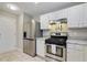 Well-lit kitchen featuring stainless steel appliances, granite countertops, and white cabinets at 455 Registry Blf, Stone Mountain, GA 30087