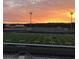 Beautiful dusk view of the football field with stadium lights, vibrant sunset, and inviting athletic space at 133 Laurel Brook Ln, Canton, GA 30115