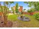 Lush green backyard with brick home, fire pit, landscaping, and privacy fence for outdoor enjoyment at 1250 Rosette Way, Marietta, GA 30062