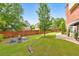 Serene backyard with stone-edged landscaping, a fire pit, lush lawn, and fencing for privacy and beauty at 1250 Rosette Way, Marietta, GA 30062
