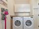 Laundry area with side by side washer and dryer, overhead storage, and bright lighting at 1250 Rosette Way, Marietta, GA 30062