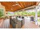Covered outdoor patio featuring dining area, ceiling fans, and views of the landscaped pool and yard at 1250 Rosette Way, Marietta, GA 30062