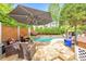 An inviting in-ground pool with stone surround and umbrella-covered lounge area provides a relaxing outdoor space at 1250 Rosette Way, Marietta, GA 30062