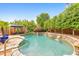 Backyard pool featuring stone accents, lush landscaping, multiple waterfall features and comfortable lounge area at 1250 Rosette Way, Marietta, GA 30062
