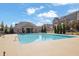 Community pool with ample seating surrounded by well-maintained landscaping and beautiful townhomes at 235 Commons Ave, Woodstock, GA 30188