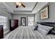 Comfortable main bedroom featuring a tray ceiling, ceiling fan, and relaxing decor at 3986 Church View Ln, Suwanee, GA 30024