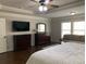 This main bedroom features dark furniture, a ceiling fan and lots of natural light from the windows at 4241 Summer Breeze Way, Buford, GA 30518