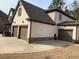 Angle view of home's facade and 3-car garage with stone accents at 4241 Summer Breeze Way, Buford, GA 30518