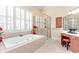Bright bathroom with a large soaking tub, shower, and a vanity area at 8095 Georgetown Cir, Suwanee, GA 30024