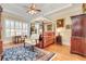 An elegant bedroom features a canopy bed, a cozy seating area, and a window with shutters at 8095 Georgetown Cir, Suwanee, GA 30024