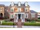 Stunning two-story brick home with a manicured lawn, dormer windows, and lion statues at the entrance at 8095 Georgetown Cir, Suwanee, GA 30024