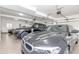Pristine three-car garage with three luxury cars parked inside at 8095 Georgetown Cir, Suwanee, GA 30024