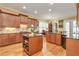 Gourmet kitchen featuring custom cabinets, hardwood floors, stainless steel appliances, and a functional center island at 8095 Georgetown Cir, Suwanee, GA 30024