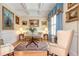 Comfortable living room featuring elegant seating, classic artwork, and a refined rug on beautiful hardwood floors at 8095 Georgetown Cir, Suwanee, GA 30024