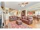 A spacious living room with hardwood floors, a fireplace, and access to a staircase with decorative art at 8095 Georgetown Cir, Suwanee, GA 30024