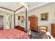 Bedroom showcasing a classic canopy bed, hardwood floors, and elegant furnishings at 8095 Georgetown Cir, Suwanee, GA 30024