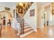 A grand staircase featuring decorative art, hardwood floors, and elegant lighting at 8095 Georgetown Cir, Suwanee, GA 30024