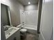 Tiled bathroom features shower and tub combo with a modern vanity and fixtures at 223 Willow St, Canton, GA 30114