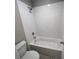 White tiled shower and tub combo with modern fixtures in a well-lit bathroom at 223 Willow St, Canton, GA 30114