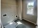 Bright laundry room with tile flooring, storage shelf and natural light from a window at 223 Willow St, Canton, GA 30114