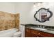 Bathroom featuring a decorative mirror, granite counters, tub and dark wood cabinets at 3635 E Paces Ne Cir # 1405, Atlanta, GA 30326