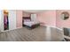 Bedroom with light pink walls, wood-look flooring, and open closet with mirrored doors at 4381 Prather Son Dr, Loganville, GA 30052