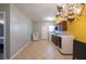 Spacious laundry room with tile floor, chandelier lighting, washer, dryer, sink, and dark cabinets at 4381 Prather Son Dr, Loganville, GA 30052